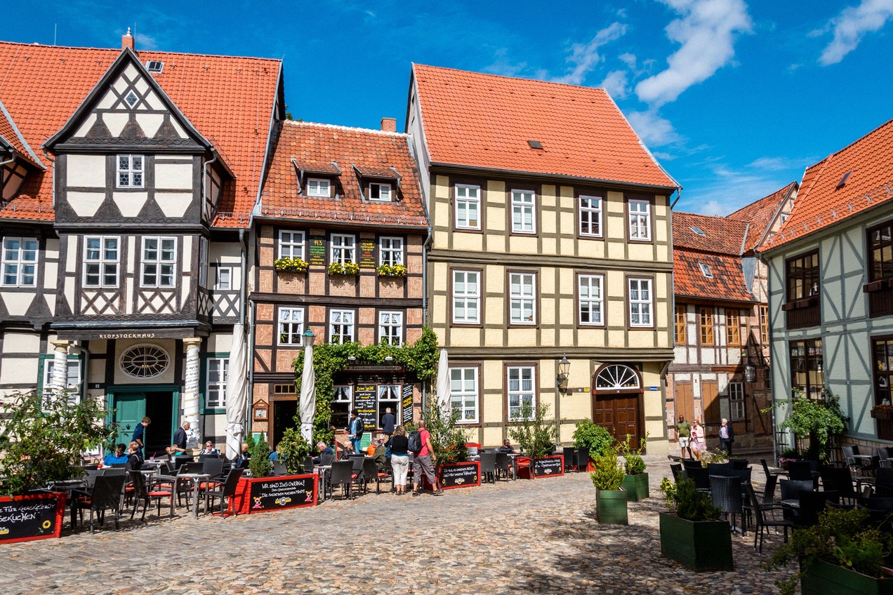 Historischer Platz in der Quedlinburger Altstadt mit prächtigen Fachwerkhäusern, Kopfsteinpflaster und Außengastronomie, die Stadt im Harz zählt zum…